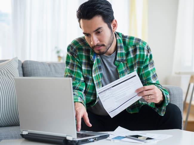 Persona usando un computador para cambiar el nombre en su factura (Foto vía GettImages)