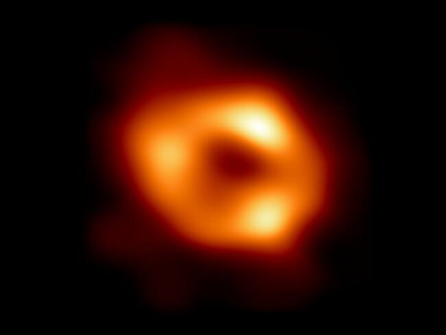 IN SPACE -  MAY 12: In this handout photo provided by NASA,  This is the first image of Sgr A*, the supermassive black hole at the centre of our galaxy, with an added black background to fit wider screens. It&#039;s the first direct visual evidence of the presence of this black hole. It was captured by the Event Horizon Telescope (EHT), an array which linked together eight existing radio observatories across the planet to form a single Earth-sized virtual telescope. The telescope is named after the event horizon, the boundary of the black hole beyond which no light can escape.   The image of the Sgr A* black hole is an average of the different images the EHT Collaboration has extracted from its 2017 observations.  In addition to other facilities, the EHT network of radio observatories that made this image possible includes the Atacama Large Millimeter/submillimeter Array (ALMA) and the Atacama Pathfinder EXperiment (APEX) in the Atacama Desert in Chile, co-owned and co-operated by ESO is a partner on behalf of its member states in Europe. (Photo by NASA Via Getty Images)