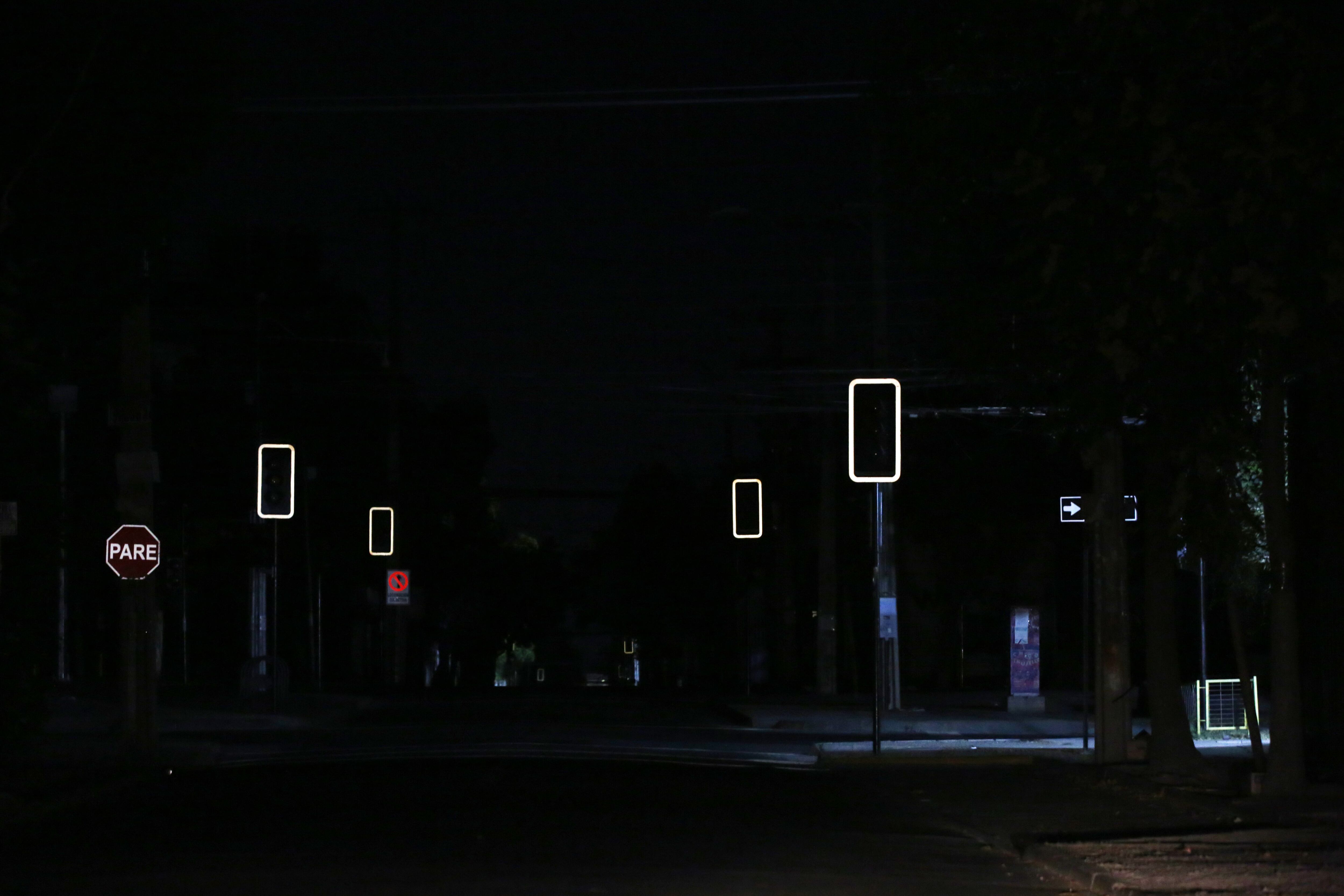 AME3599. SANTIAGO (CHILE), 25/02/2025.- Fotografía de unos semáforos apagados este martes, en Santiago (Chile). Chile se prepara para pasar una noche sin suministro eléctrico después de que fallaran los tres intentos por reparar el corte de energía ocurrido en la tarde de este martes y que afecta al 99 % del país. EFE/ Elvis González