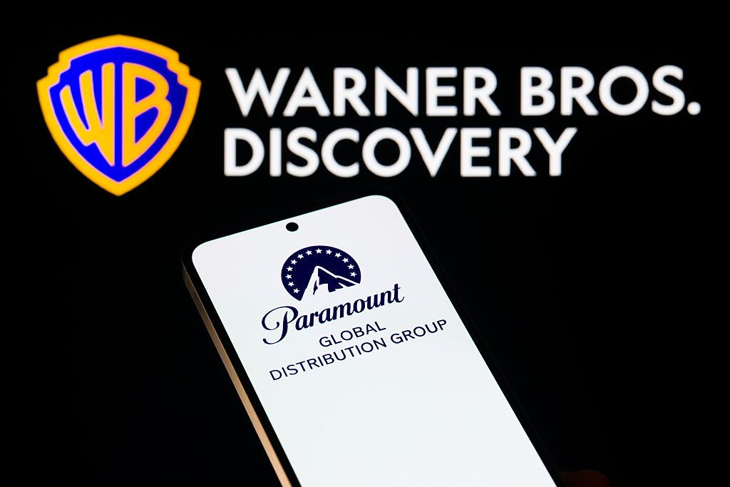The Paramount logo is displayed on a mobile phone with the Warner Bros. Discovery logo seen in the background, in this photo illustration in Brussels, Belgium, on December 9, 2025. (Photo by Jonathan Raa/NurPhoto via Getty Images)