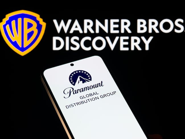 The Paramount logo is displayed on a mobile phone with the Warner Bros. Discovery logo seen in the background, in this photo illustration in Brussels, Belgium, on December 9, 2025. (Photo by Jonathan Raa/NurPhoto via Getty Images)