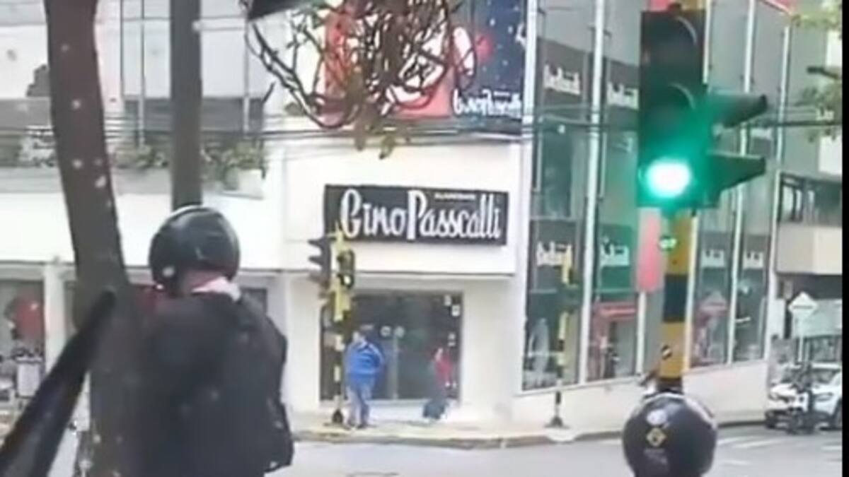 Paró la moto en un semáforo para orinar en un árbol