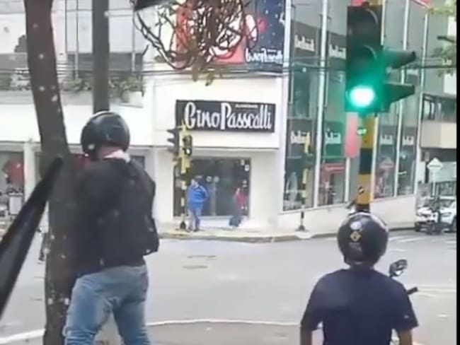 Paró la moto en un semáforo para orinar en un árbol