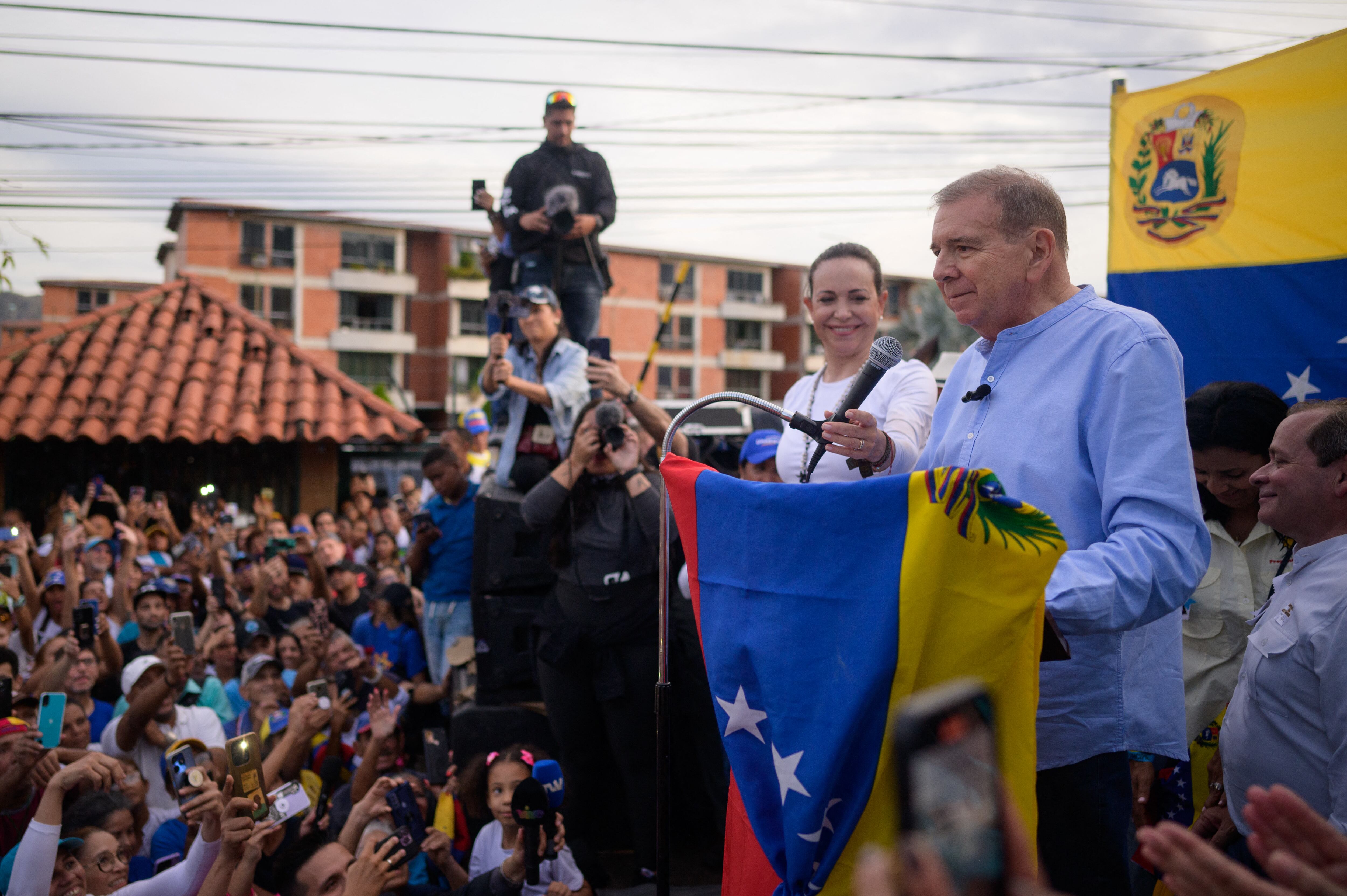 Venezuelan opposition presidential candidate for the Plataforma Unitaria Democratica party, Edmundo Gonzalez Urrutia (R), speaks next to Venezuelan opposition leader Maria Corina Machado (2nd-R) during a campaign rally in Guatire, Miranda State, Venezuela, on May 31, 2024. (Photo by Gabriela Oraa / AFP)