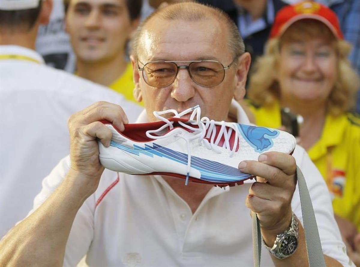 Un espectador exhibe su trofeo, la zapatilla del hombre más rápido del mundo, Usain Bolt.