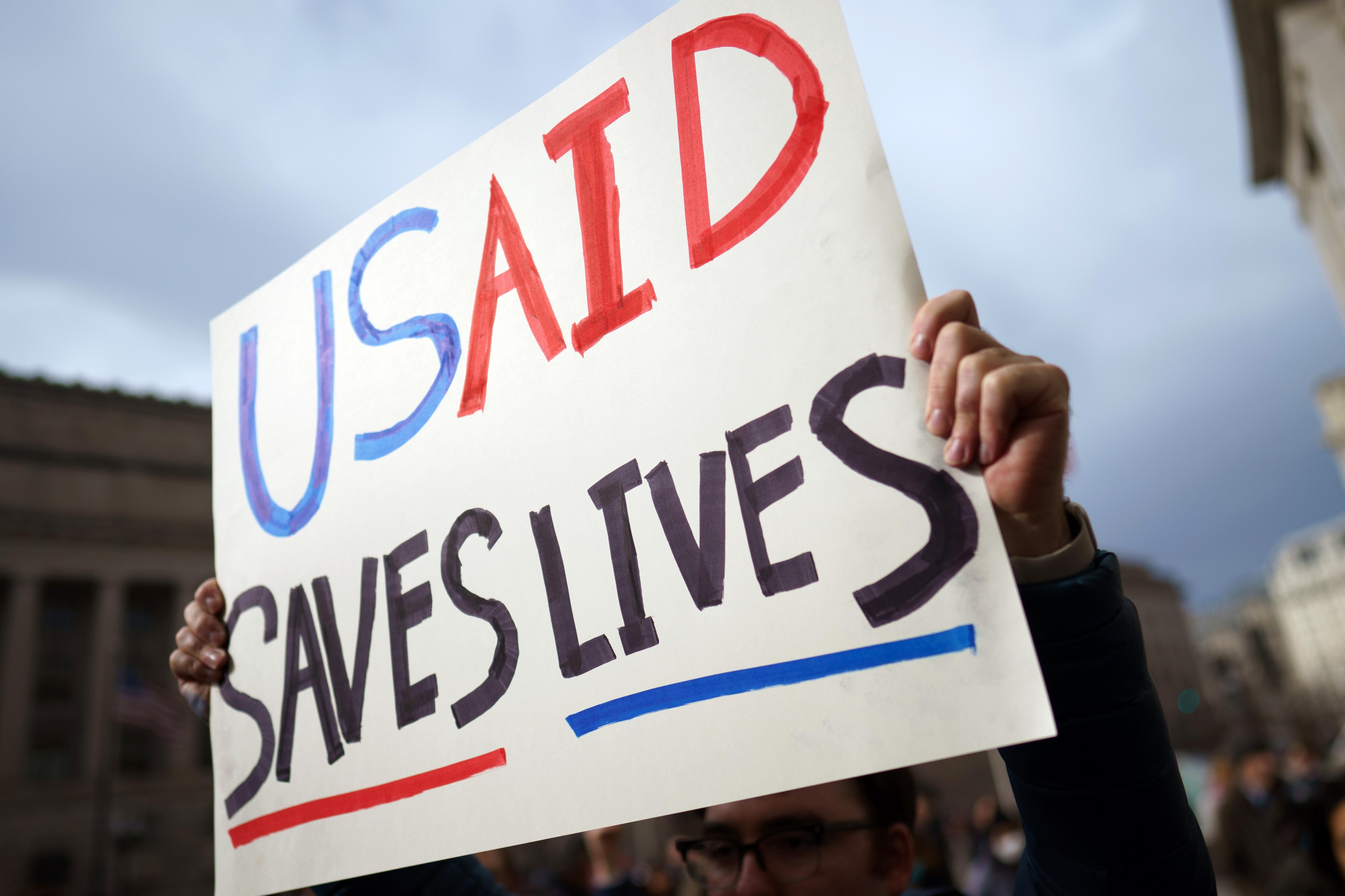 Washington (United States), 03/02/2025.- A protester holds a placard outside the US Agency for International Development (USAID) in Washington, DC, USA, 03 February 2025. Staffers at USAID have been instructed via an email to stay away from the agency's Washington headquarters on 03 February 2025, following a weekend takeover by an announcement by US billionaire Elon Musk that President Trump had agreed with him to shut the agency down. (Protestas) EFE/EPA/WILL OLIVER