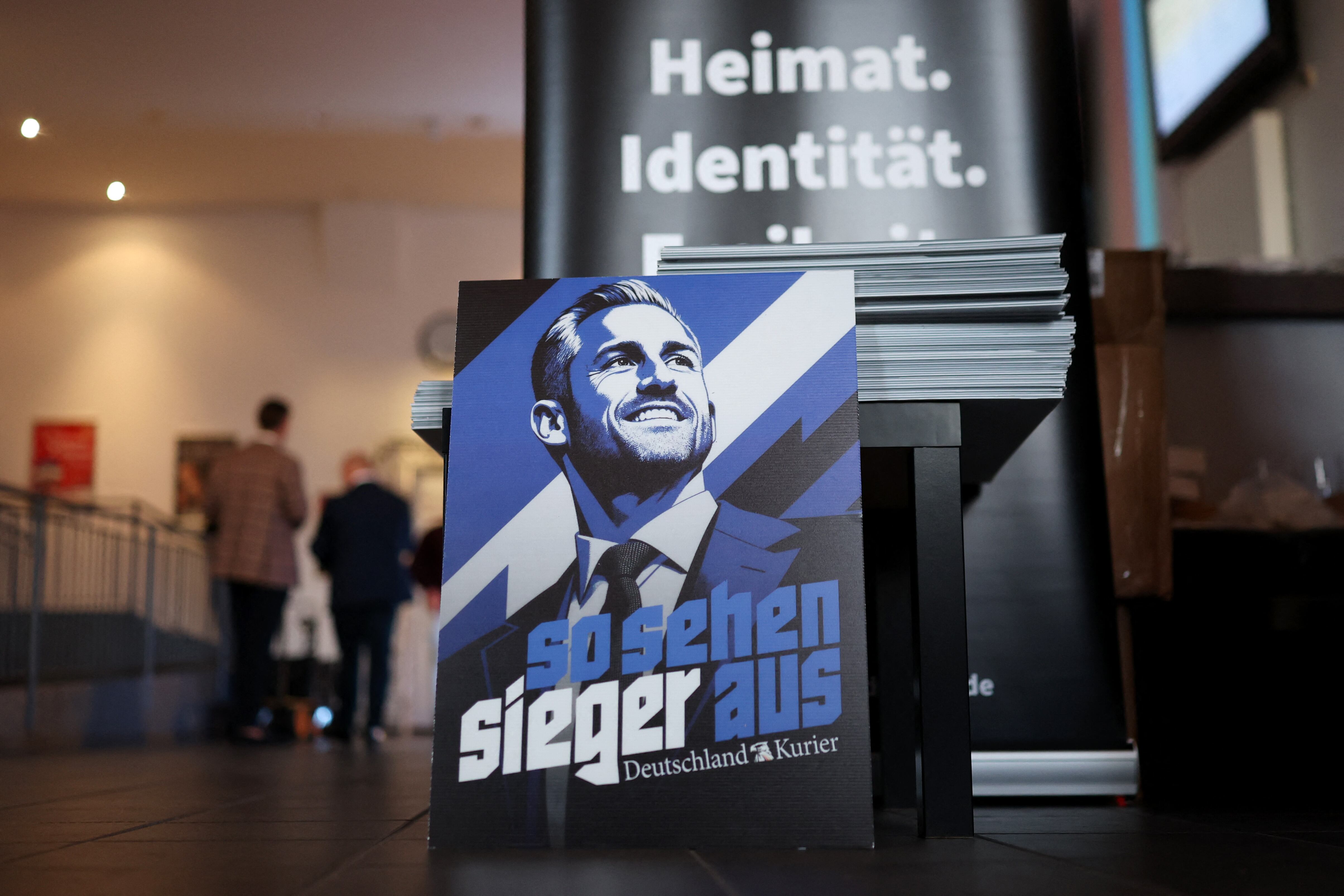 An election poster by the publication 'Deutschland-Kurier', which is considered close to the far-right Alternative for Germany (AfD) party, shows AfD's main candidate in the Saxony-Anhalt state election Ulrich Siegmund at the venue of the AfD election party following Saxony-Anhalt's state elections in Magdeburg, eastern Germany on September 6, 2026. Germany's far-right AfD won a landslide victory in a key regional election on September 6 in the ex-communist east, according to exit polls, but it remains unclear whether it can win an absolute majority to govern. (Photo by Ronny HARTMANN / AFP)