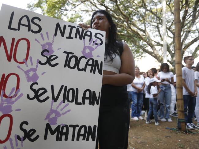 AME3818. CALI (COLOMBIA), 11/12/2023.- Familiares y amigos asisten hoy al velorio de Michelle Dayana González, una menor de 14 años que fue asesinada y descuartizada en un centro automotor, en Cali (Colombia). Una docena de velas, una veintena de ramos de flores y pancartas exigiendo justicia rodean el féretro de Michelle Dayana González, la niña de 14 años que fue asesinada y desmembrada en la noche del pasado 7 de diciembre en un feminicidio cometido en el barrio San Judas de la ciudad de Cali, en el suroeste de Colombia. Su velorio se realiza en el polideportivo del barrio que la vio crecer y en el que también estaba ubicado el taller donde un hombre, el sospechoso del crimen, la llevó con engaños para cometer el asesinato. El lugar ahora está decorado con grafitis que dicen las niñas no se tocan, no se matan. EFE/Ernesto Guzmán