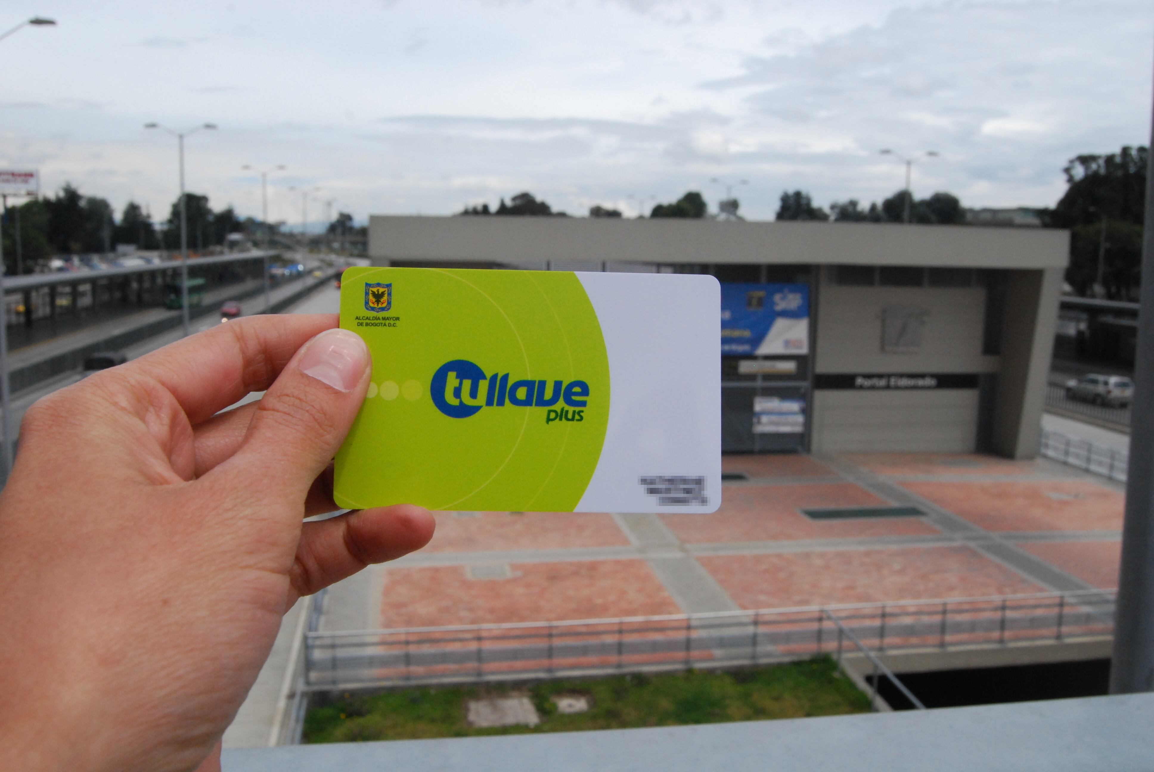 Tarjeta TuLlave Plus personalizada y al fondo una estación de Transmilenio. (Foto: Colprensa).