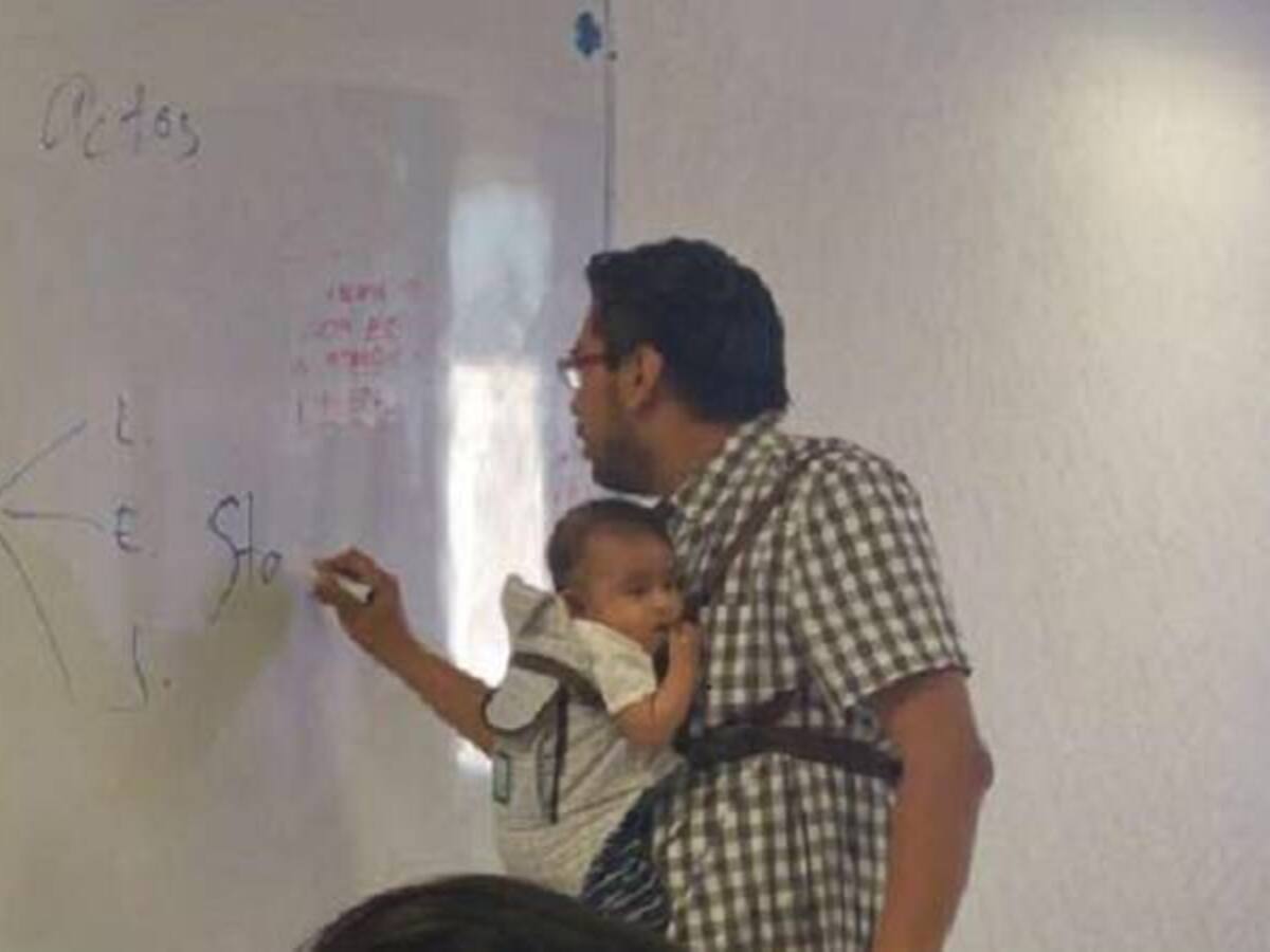 Profesor carga el bebé de una alumna para que ella tome apuntes de la clase