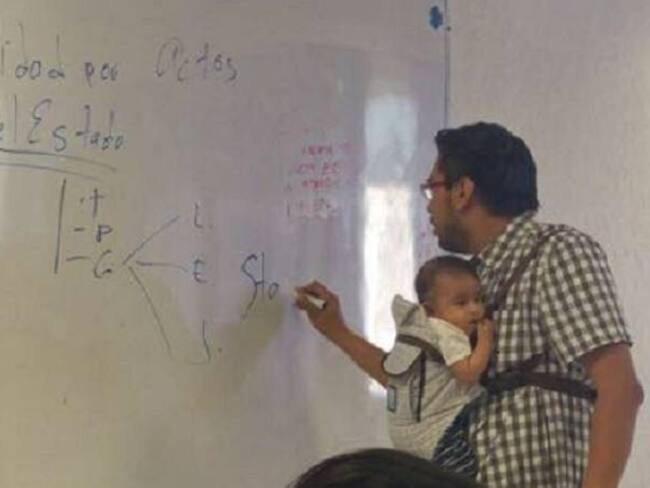 Profesor carga el bebé de una alumna para que ella tome apuntes de la clase