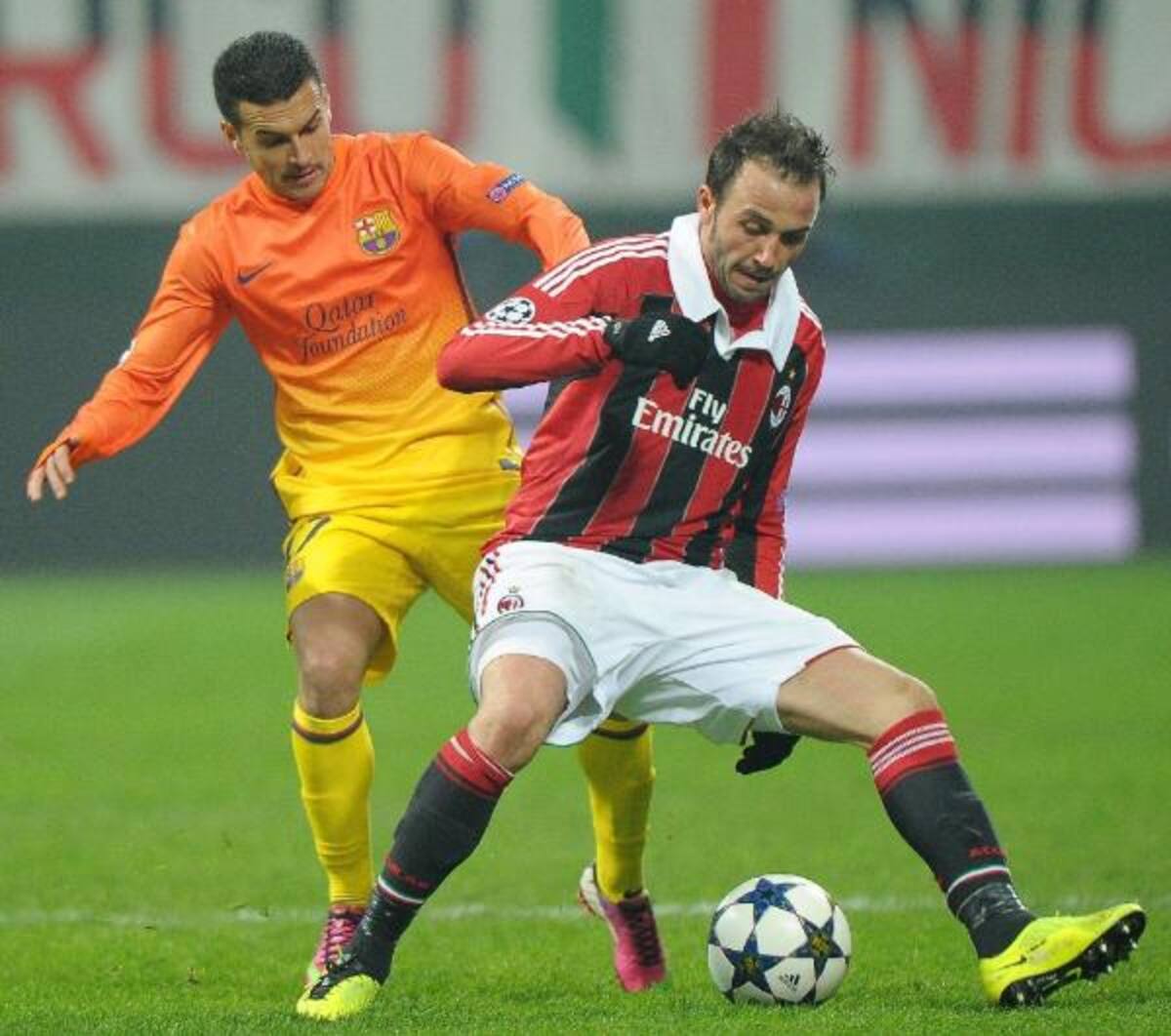 El jugador del Milán Giampaolo Pazzini (d) protege el balón ante Pedro Rodríguez, del FC Barcelona