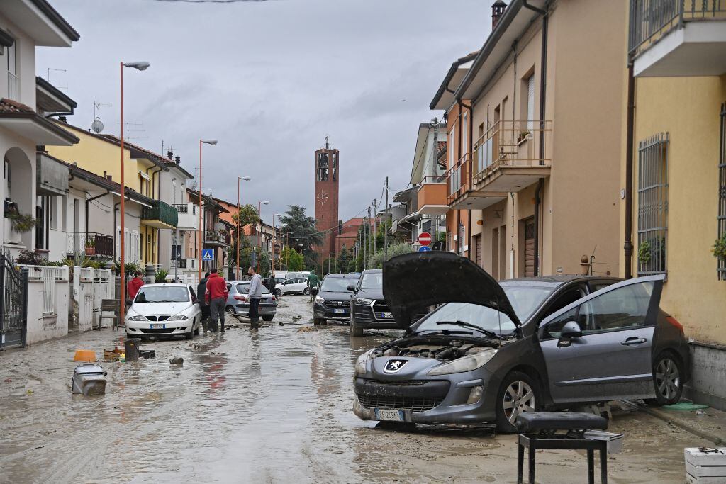 Local residents observe the aftermath of a flooding in a street of the San Rocco district of Cesena on May 17, 2023. Heavy rains have caused major floodings in central Italy, where trains were stopped and schools were closed in many towns while people were asked to leave the ground floors of their homes and to avoid going out. Five people have died after the floodings across Italy's northern Emilia Romagna region, a local official said. (Photo by Alessandro SERRANO / AFP) (Photo by ALESSANDRO SERRANO/AFP via Getty Images)