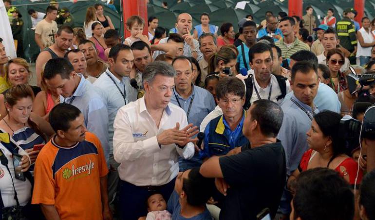 Fotografía cedida por la Presidencia de Colombia del mandatario colombiano, Juan Manuel Santos (C), hablando con colombianos deportados desde Venezuela en el albergue del Coliseo Francisco de Paula Santander.