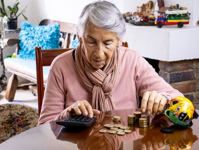 Mujer adulta mayor contando dinero (Foto vía Getty Images).