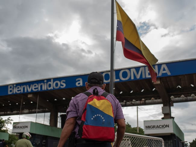 Hombre con maleta que tiene bandera venezolana cruza la frontera para ingrsar a Colombia.
(Foto: Hector Quintanar/Getty Images)