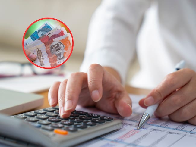 Persona haciendo cuentas en una calculadora y de fondo dinero colombiano (Fotos vía Getty Images)