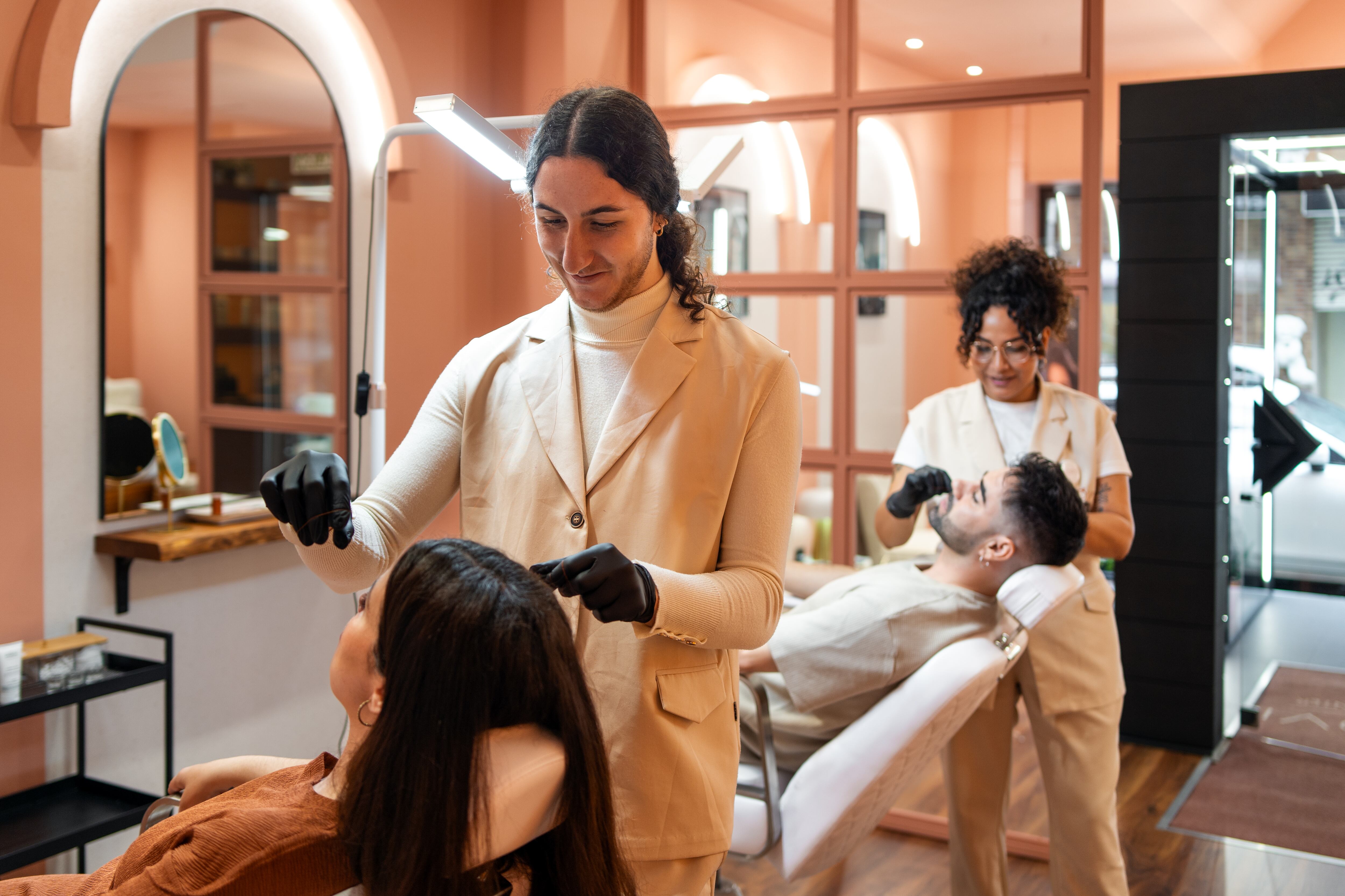 Salón de belleza en donde una mujer y un hombre reciben cortes de pelo (Crédito: Getty Images)
