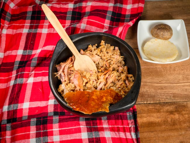 Porción de lechona, con una parte del cuero del cerdo, y acompañada de papa salada y arepa (Getty Images)