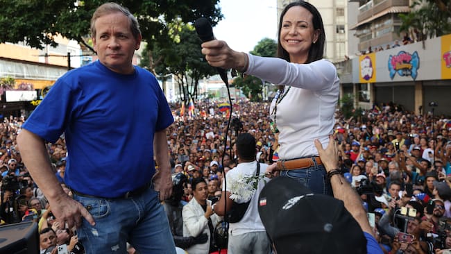 AME9799. CARACAS (VENEZUELA), 09/01/2025.- La líder antichavista María Corina Machado (d) saluda a sus seguidores junto al exdiputado venezolano Juan Pablo Guanipa este jueves, en una manifestación en Caracas (Venezuela). Machado anunció, a un día de la toma de posesión presidencial, el comienzo de una "nueva fase" del proceso para "la libertad de Venezuela", y pidió a los ciudadanos estar atentos a las señales sobre los próximos pasos. EFE/ Miguel Gutiérrez