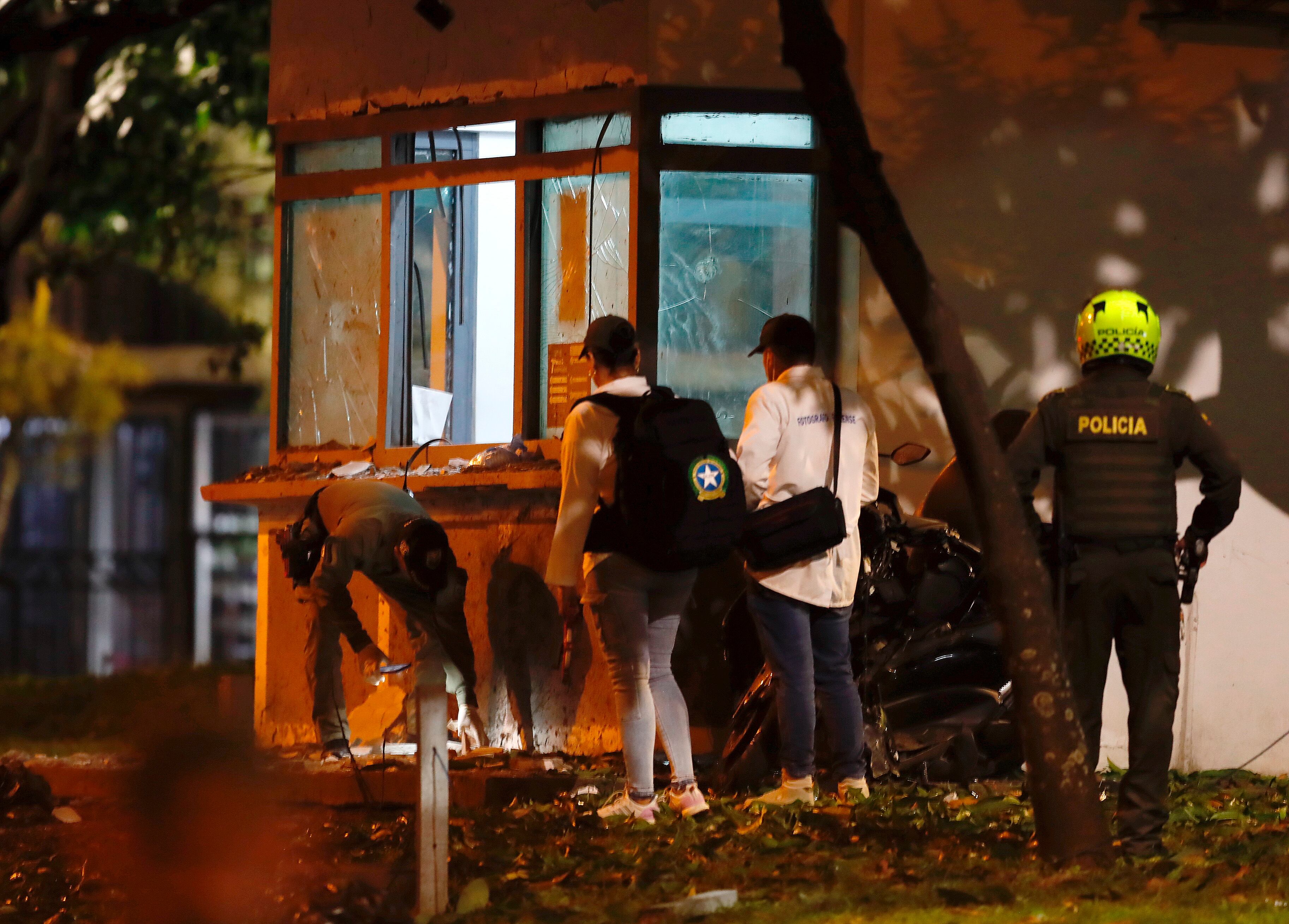 AME2553. CALI (COLOMBIA), 25/04/2025.- Policías buscan evidencias en cercanías de un CAI (Comando de Atención Inmediata de Policía), luego de presentarse un atentado con explosivos este viernes en Cali (Colombia). EFE/ Ernesto Guzmán