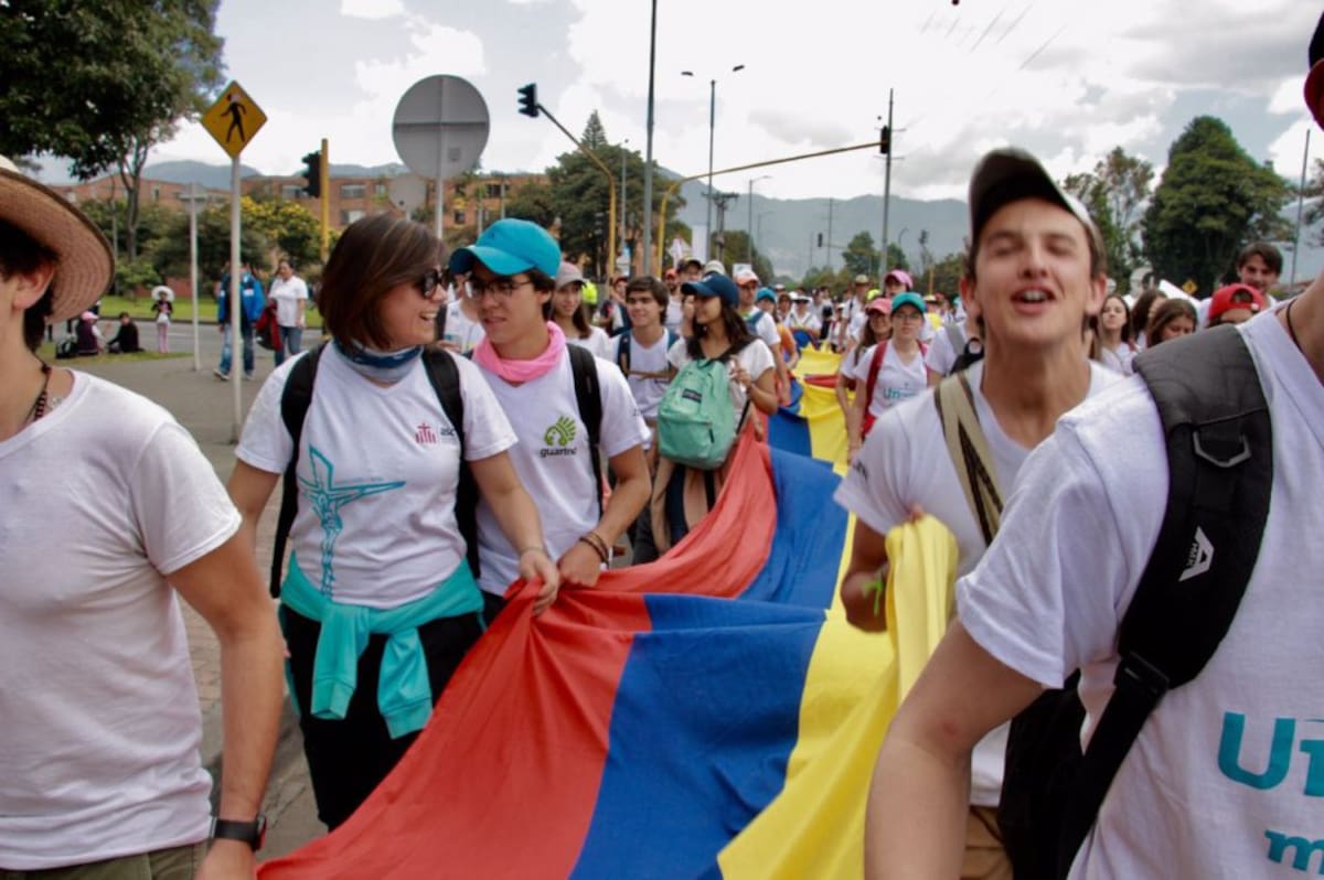 Personas con la bandera de Colombia, caminan hacia el Parque Simón Bolívar