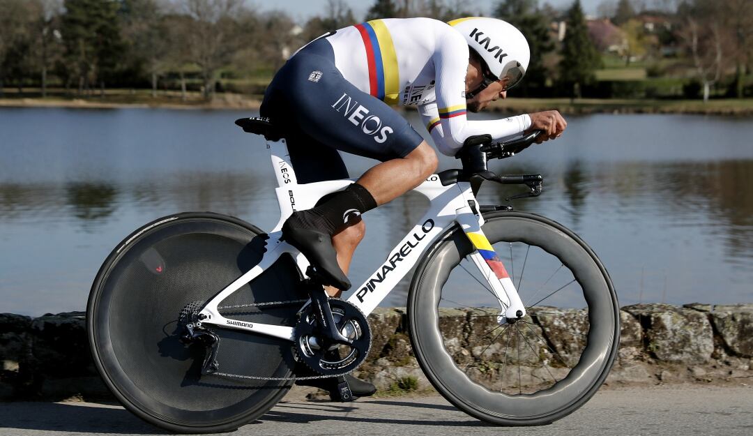 Daniel Felipe Martínez corriendo con la bandera nacional durante la prueba contrarreloj de la París-Niza.