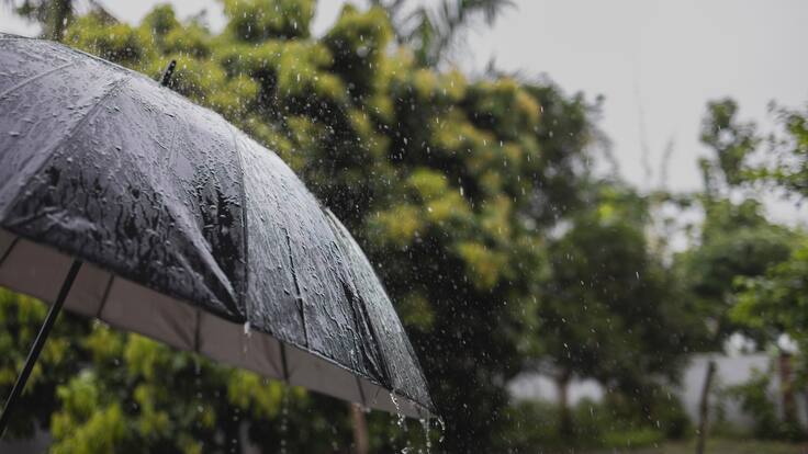 Día lluvioso y persona sosteniendo una sombrilla (Foto vía Getty Images)