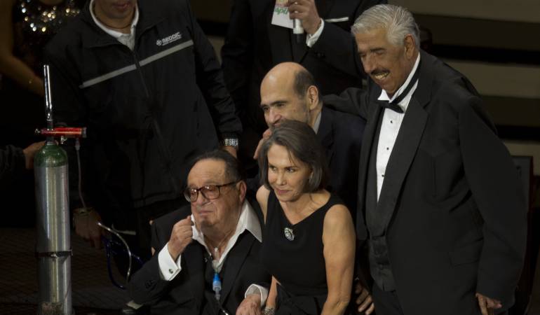 El actor Rubén Aguirre, en un homenaje a Roberto Gómez Bolaños. En la imagen también aparecen Florinda Meza y atrás Edgar Vivar, quien confirmó la muere del "profesor Jirafales".