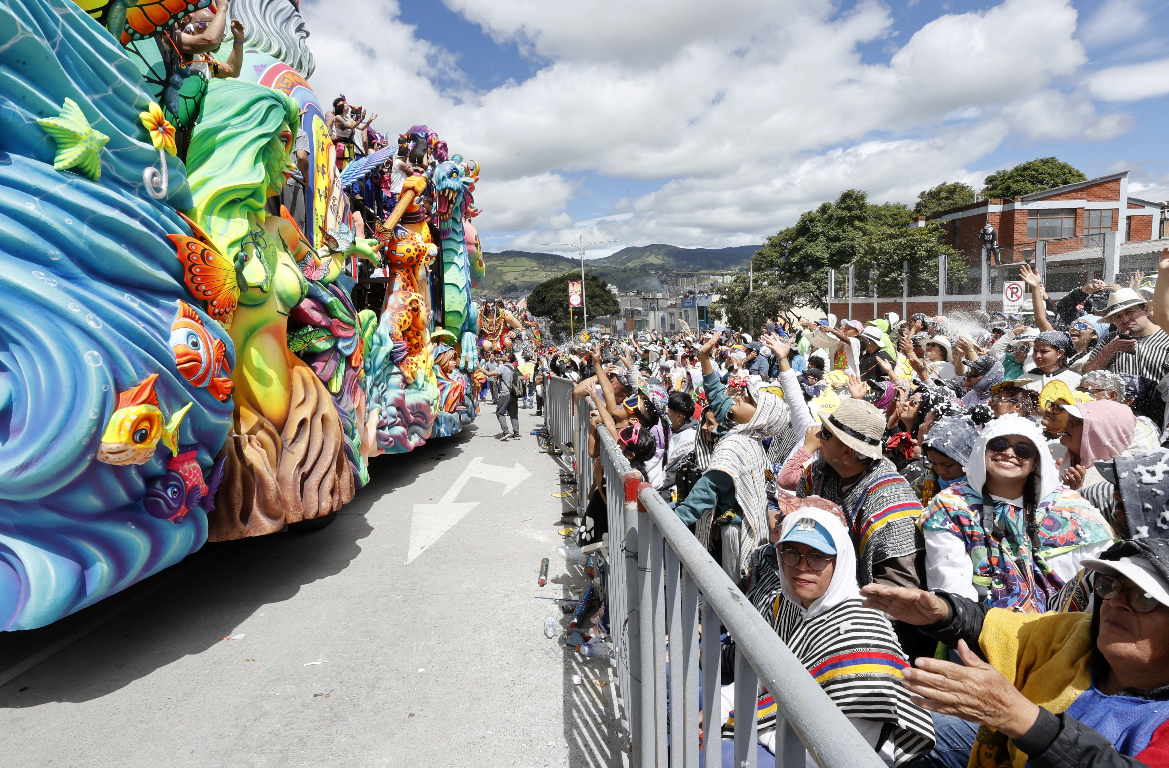 AME9033. PASTO (COLOMBIA), 06/01/2025.- Asistentes observan carrozas durante el Desfile Magno en el marco del Carnaval de Negros y Blancos, este lunes en Pasto (Colombia). El Desfile Magno de carrozas se tomó las principales calles en el cierre del Carnaval de Negros y Blancos, proclamado por la Unesco en 2009 como Obra Maestra del Patrimonio Cultural Inmaterial de la Humanidad. EFE/ Mauricio Dueñas Castañeda