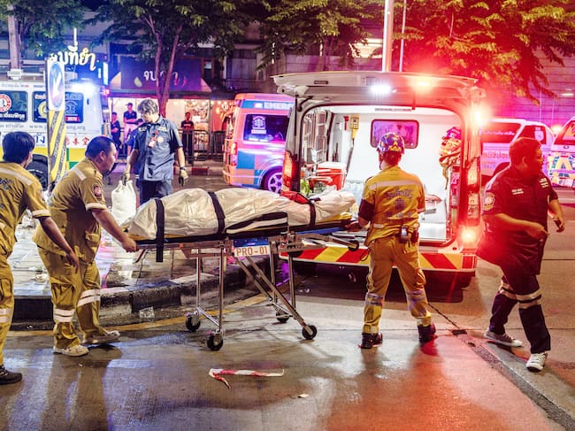Emergency workers prepare to place the body of a victim into an ambulance after a fire at the Rong Beer Na Lat Phrao bar in Bangkok on July 13, 2026. A massive fire in a Bangkok bar late on July 12 killed at least 27 people and injured dozens, sending screaming patrons fleeing as flames shot from the entrance, according to officials and video verified by AFP. (Photo by chanakarn LAOSARAKHAM / AFP)