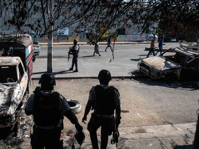 Policías custodian los exteriores comisaría de Carrefour Aéroport, que fue incendiada por miembros de pandillas, en Puerto Príncipe (Haití).
EFE/ Johnson Sabin