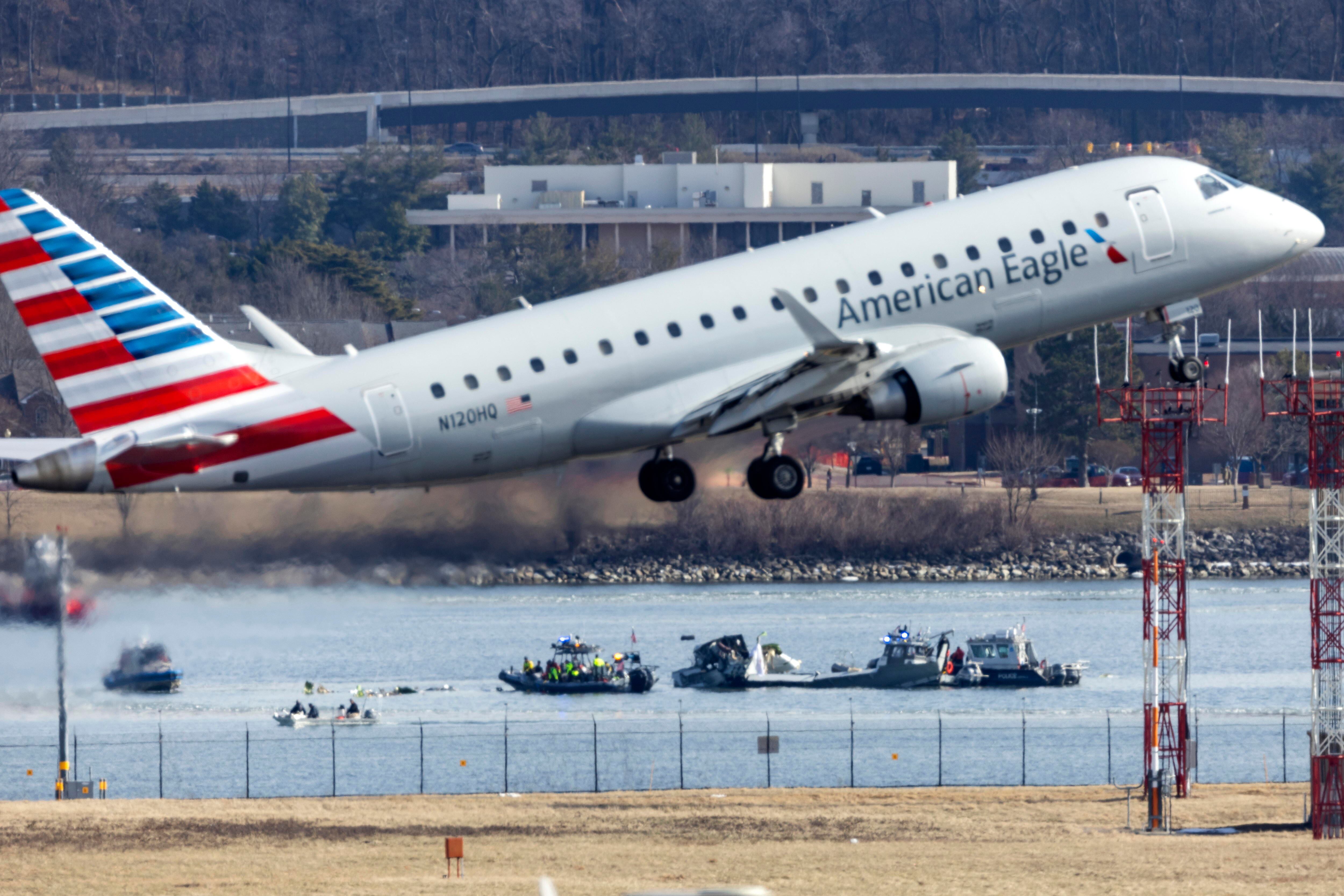 Washington (United States), 30/01/2025.- An American Eagle flight takes off from Ronald Reagan Washington National Airport in front of the wreckage of a commercial airplane that collided with a military helicopter, in Arlington, Virginia, USA, 30 January 2025. DC Fire and EMS Chief John Donnelly said no survivors are expected following the collision of an American Eagle Flight, with 60 passengers and four crew members on board, with a US Army Black Hawk helicopter carrying three US service members late on 29 January, over the Potomac River near Reagan Washington National Airport. EFE/EPA/JIM LO SCALZO