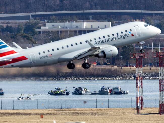 Washington (United States), 30/01/2025.- An American Eagle flight takes off from Ronald Reagan Washington National Airport in front of the wreckage of a commercial airplane that collided with a military helicopter, in Arlington, Virginia, USA, 30 January 2025. DC Fire and EMS Chief John Donnelly said no survivors are expected following the collision of an American Eagle Flight, with 60 passengers and four crew members on board, with a US Army Black Hawk helicopter carrying three US service members late on 29 January, over the Potomac River near Reagan Washington National Airport. EFE/EPA/JIM LO SCALZO