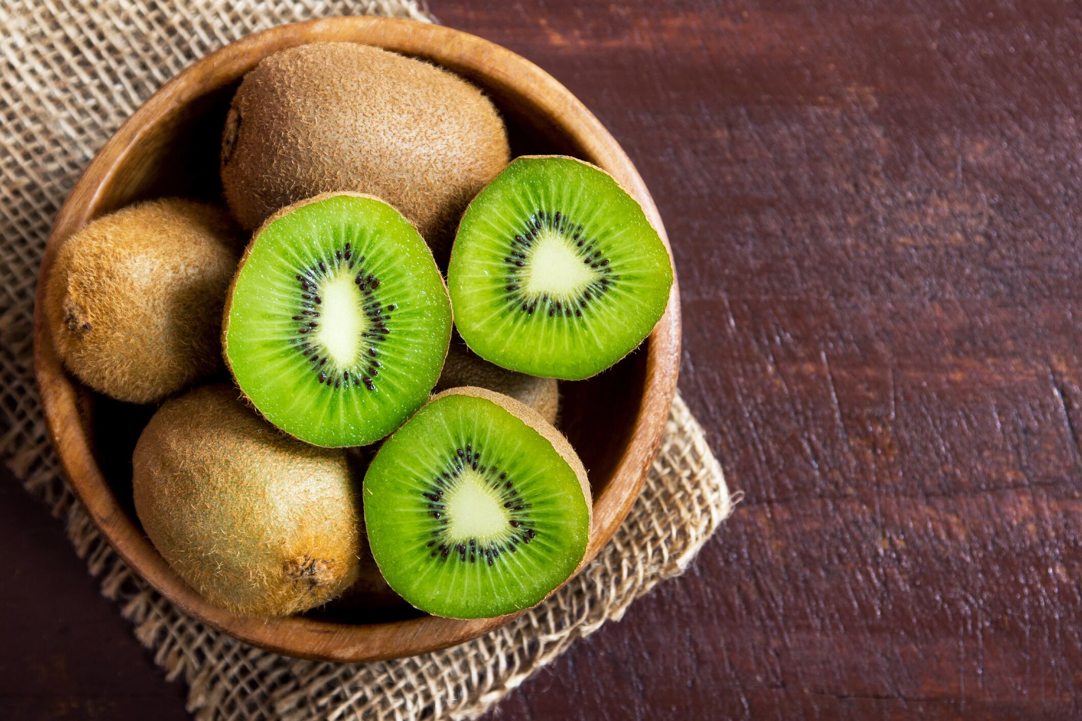 Un tazón con kiwis sobre una mesa de madera (Getty Images)