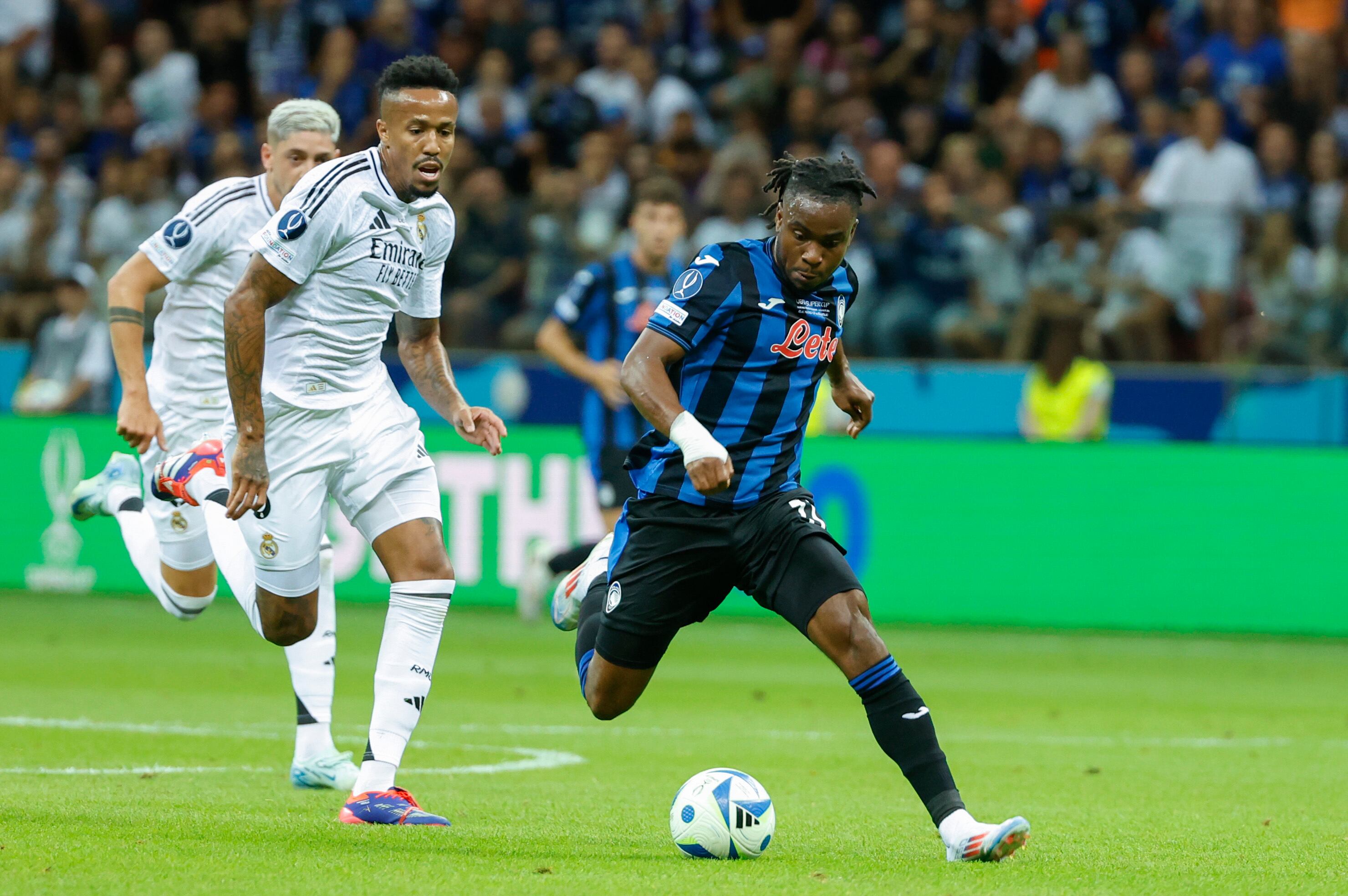 VARSOVIA, 14/08/2024.- El defensa brasileño del Real Madrid Eder Militao (i) pelea un balón con el delantero nigeriano del Atalanta Ademola Lookman durante la Supercopa de Europa de fútbol, entre el Real Madrid y el Atalanta, este miércoles en el Estadio Nacional de Polonia, en Varsovia.EFE/ Mariscal