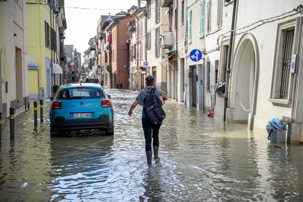 LUGO, ITALY - MAY 18: A woman walks on a flooded road during heavy rains caused flooding across Italy's northern Emilia Romagna region, on May 18, 2023 in Lugo, Italy. Nine people have died and thousands have been evacuated from their homes after torrential rain wreaked mayhem in the northern Italian region of Emilia-Romagna, causing severe flooding and landslides. (Photo by Antonio Masiello/Getty Images)