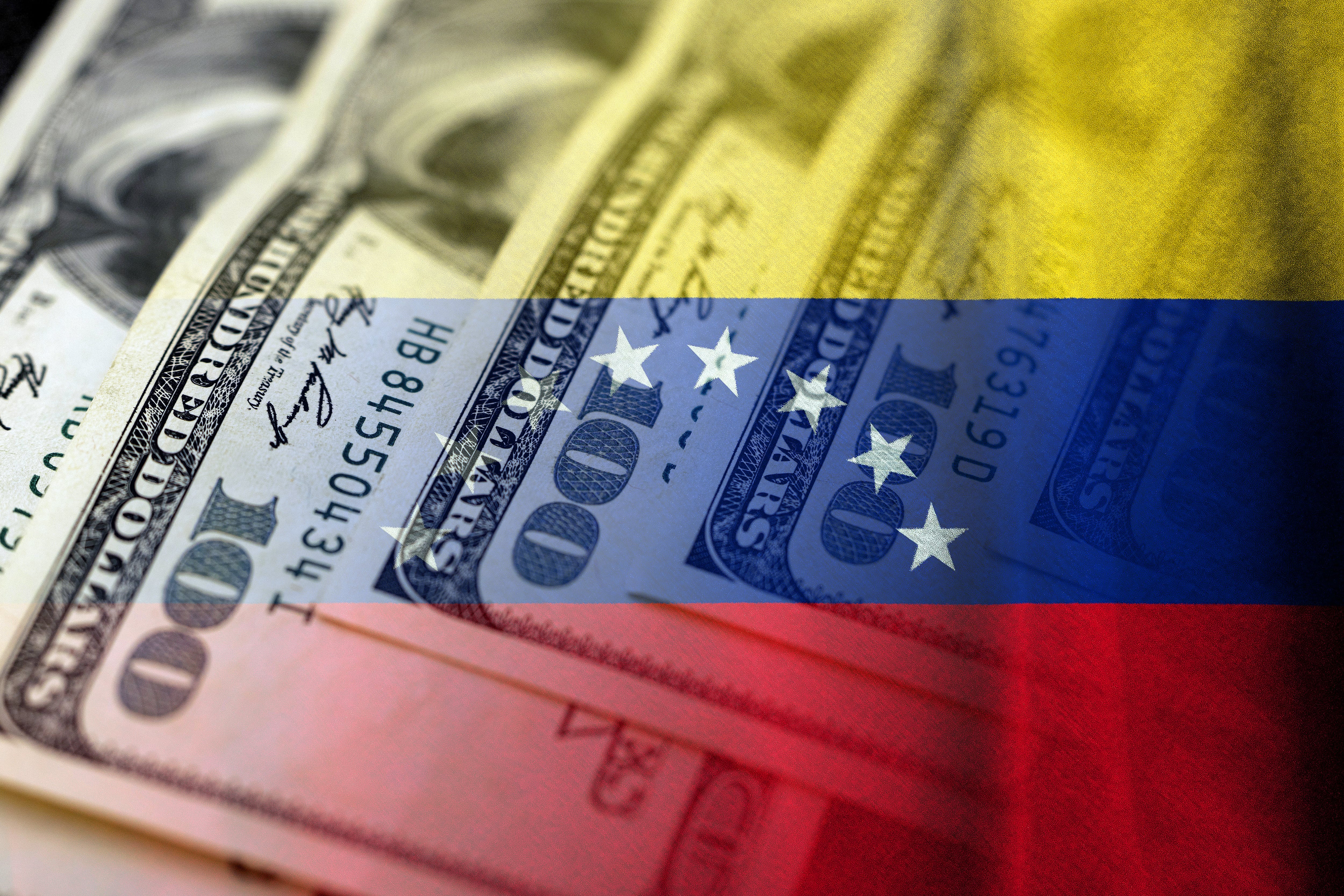 Cash dollar bills and venezuelan flag (Credito: Javier Ghersi / Getty imagenes)