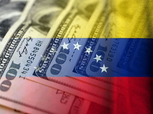 Cash dollar bills and venezuelan flag (Credito: Javier Ghersi / Getty imagenes)
