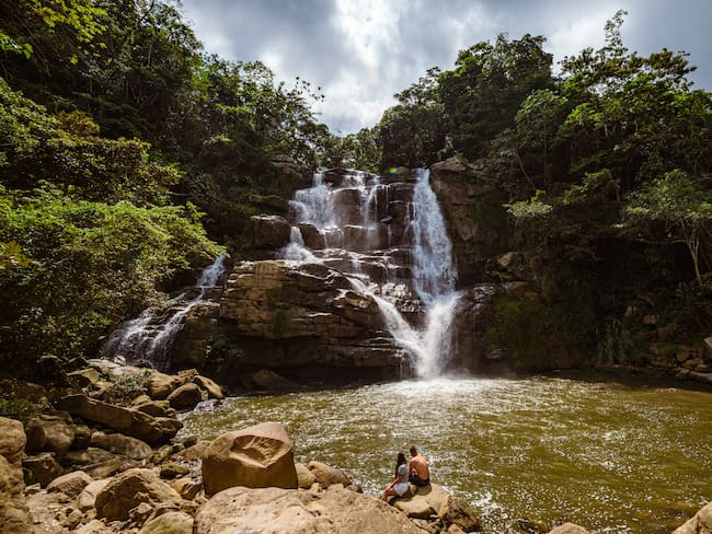 Guaduas, Cundinamarca, Colombia - January 1, 2021: Two people contemplate the tropical waterfall of Salto de Versalles./ Imagen de referencia de Getty
