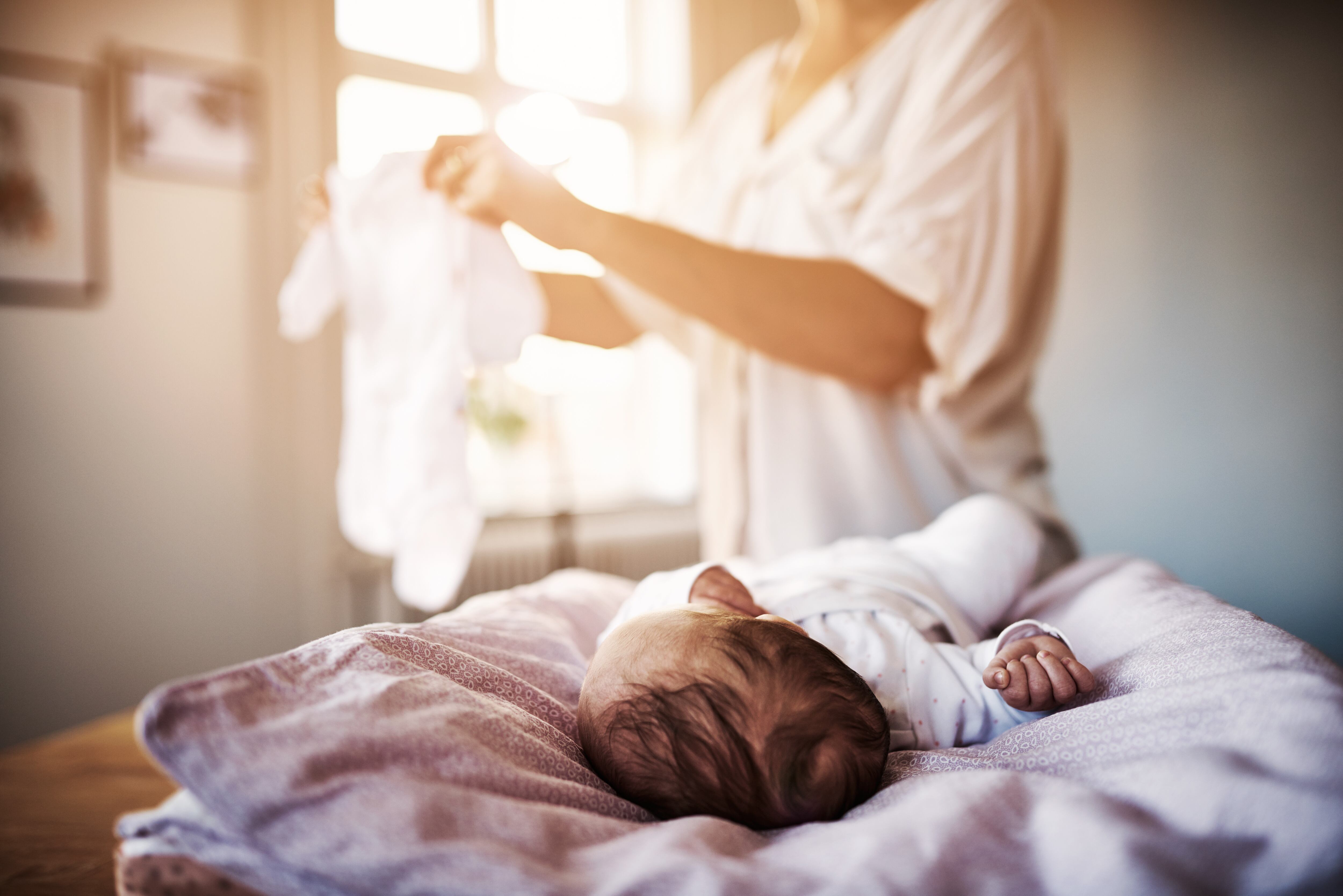 Shot of a mother changing her newborn baby girl at home