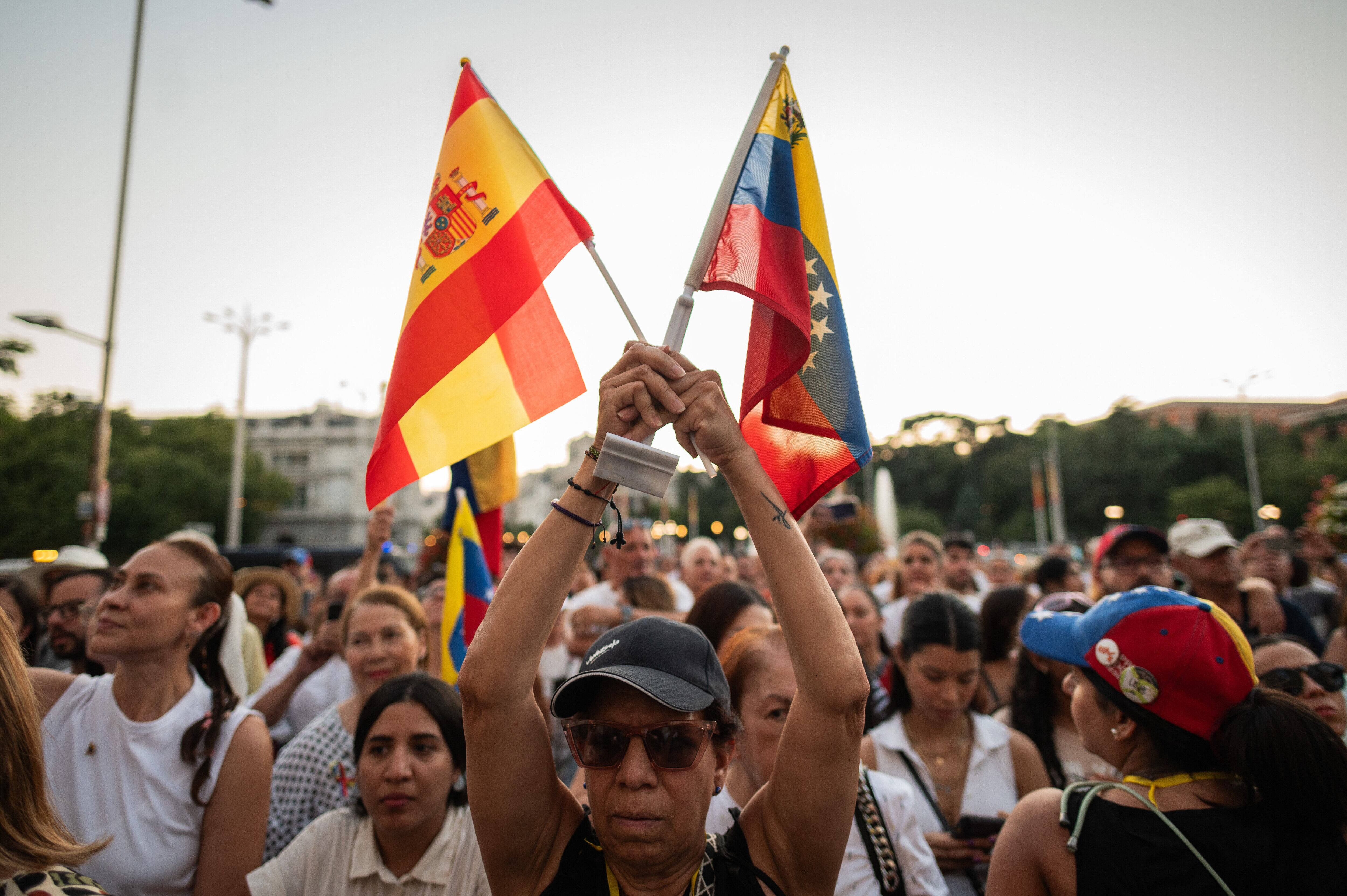 MADRID, SPAIN - 2024/08/07: A woman holds Venezuelan and Spanish flags protesting during a demonstration. Hundreds of Venezuelans living in Madrid protest in Cibeles Square against President Nicolas Maduro and demand the international community to recognize opposition leader Edmundo Gonzalez as the winner of the elections in Venezuela. (Photo by Marcos del Mazo/LightRocket via Getty Images)