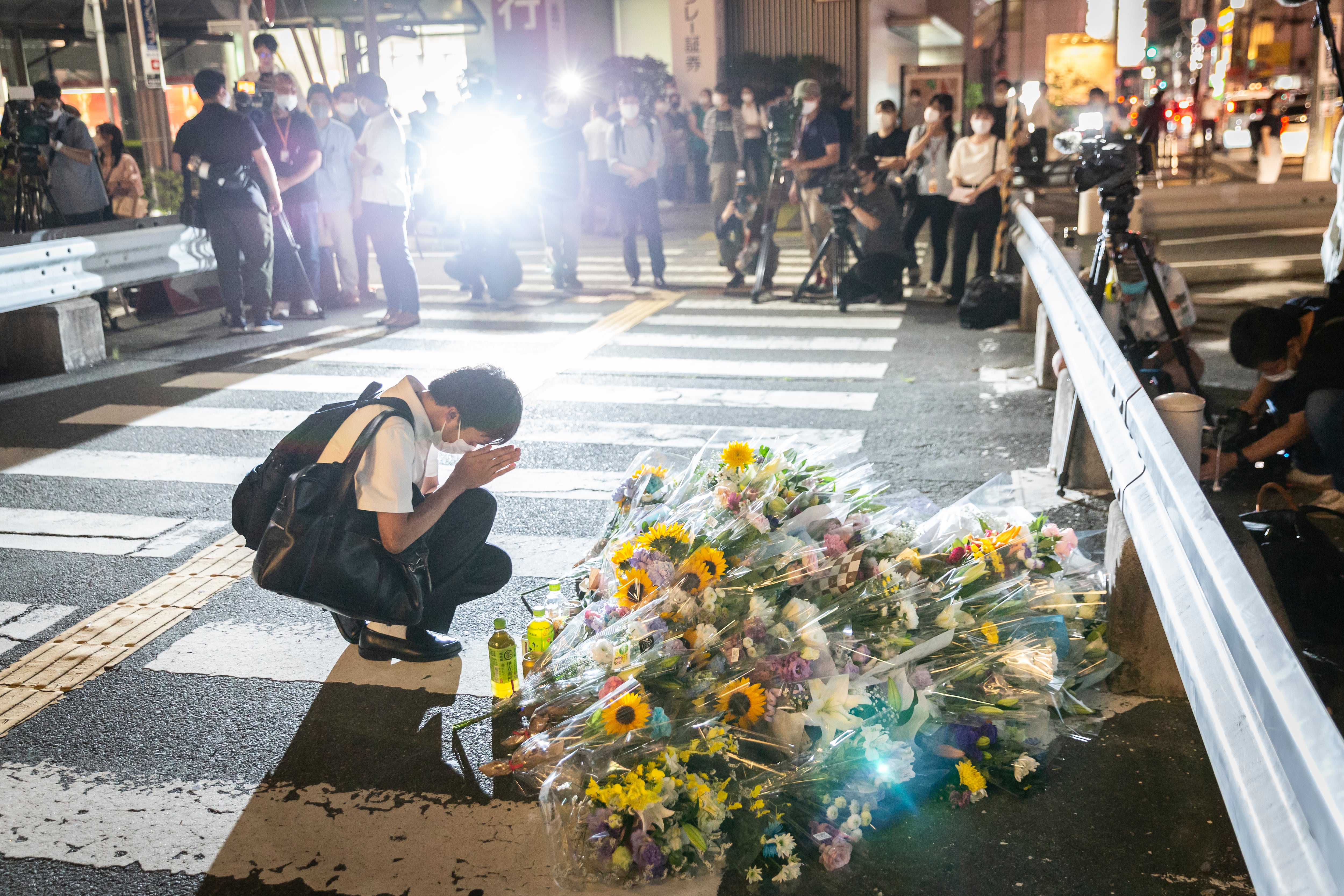 NARA JAPAN - JULY 08: A man prays at a site outside of Yamato-Saidaiji Station where Japan’s former prime minister Shinzo Abe was shot earlier today during an election campaign on July 08, 2022 in Nara, Japan. Former Prime Minister Abe has been pronounced dead, he collapsed after shots were heard while he was campaigning at a rally. A suspect was apprehended and taken into custody, as Abe was rushed to a hospital via helicopter. (Photo by Yuichi Yamazaki/Getty Images)