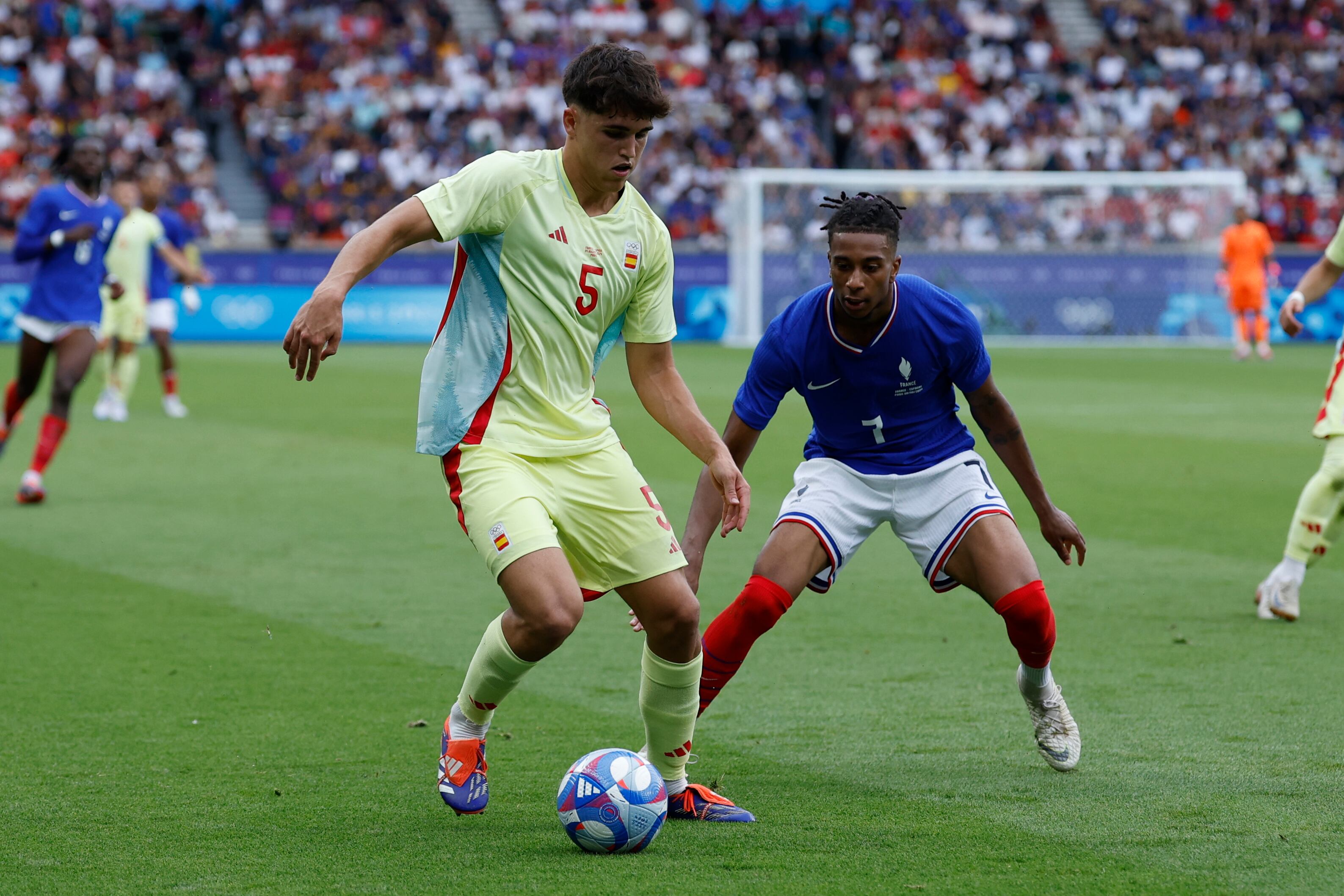 PARIS, 09/08/2024.- El jugador francés Michael Olise (d) disputa un balón ante el jugador español Pau Cubarsi durante el partido por la medalla de oro de los Juegos Olímpicos de París 2024 que Francia y España disputan este viernes en el Parc des Princes, de Paris . EFE/ JUANJO MARTIN