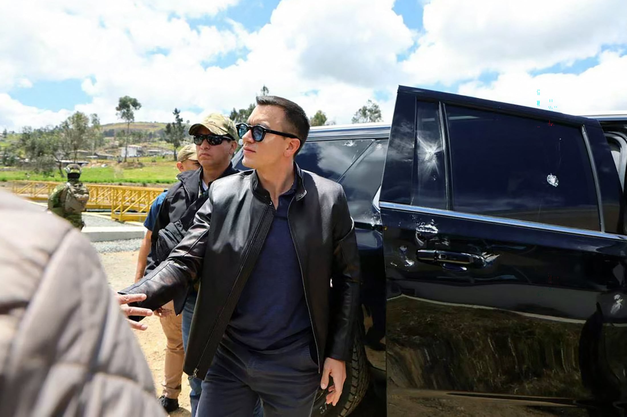 This handout picture released by the Ecuadorian Presidency shows Ecuador's President Daniel Noboa next to one of the vehicles in the motorcade he was traveling in when it was attacked by gunfire in Ca�ar, Ecuador, on October 7, 2025. Daniel Noboa emerged unharmed from an apparent gun attack on his motorcade, a minister said Tuesday, after his convoy was confronted by hundreds of people protesting diesel price hikes. (Photo by Handout / Ecuadorian Presidency / AFP) / RESTRICTED TO EDITORIAL USE - MANDATORY CREDIT "AFP PHOTO / ECUADORIAN PRESIDENCY" - HANDOUT - NO MARKETING NO ADVERTISING CAMPAIGNS - DISTRIBUTED AS A SERVICE TO CLIENTS