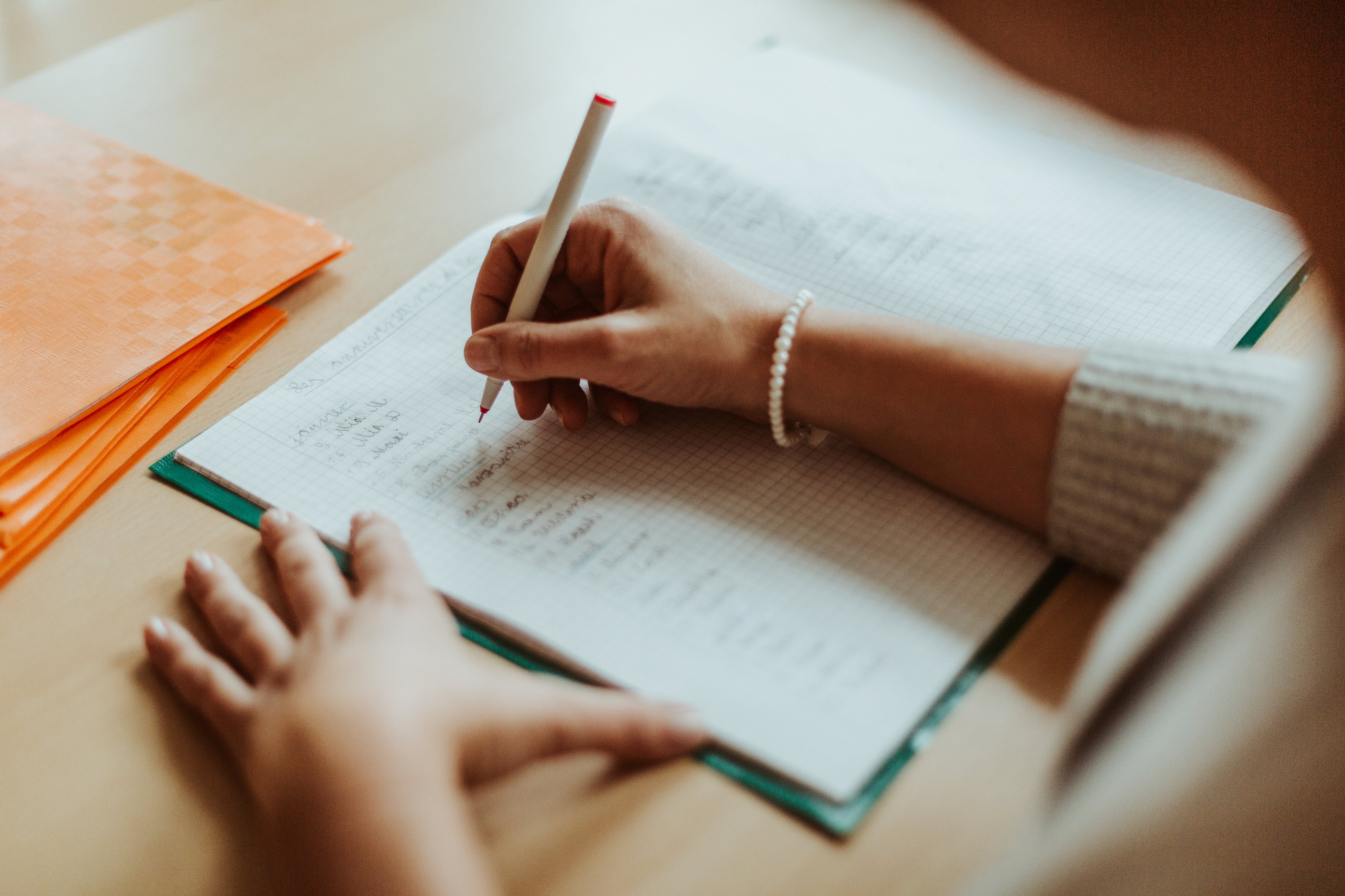 Persona escribiendo con un bolígrafo sobre un papel (Getty Images)