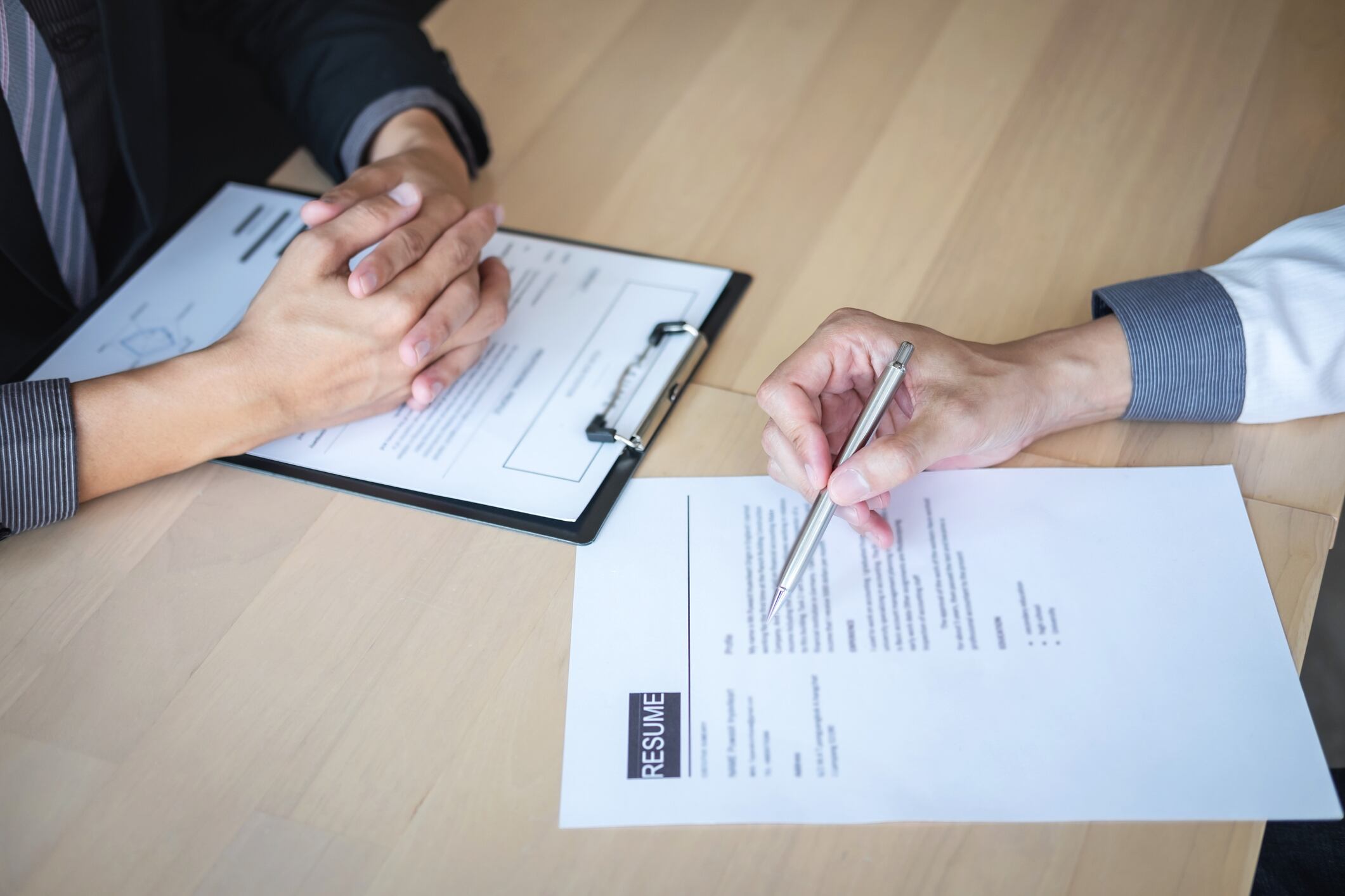 Employer or recruiter holding reading a resume during about colloquy his profile of candidate, employer in suit is conducting a job interview, manager resource employment and recruitment concept.