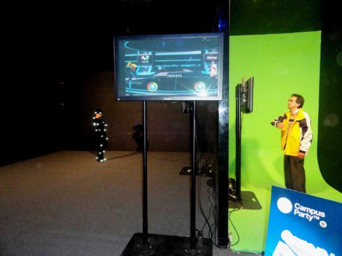 La modelo de la izquierda tiene un traje con sensores de movimiento que se transmiten en la pantalla en la que interactúa con el campusero de la habitación contigüa.