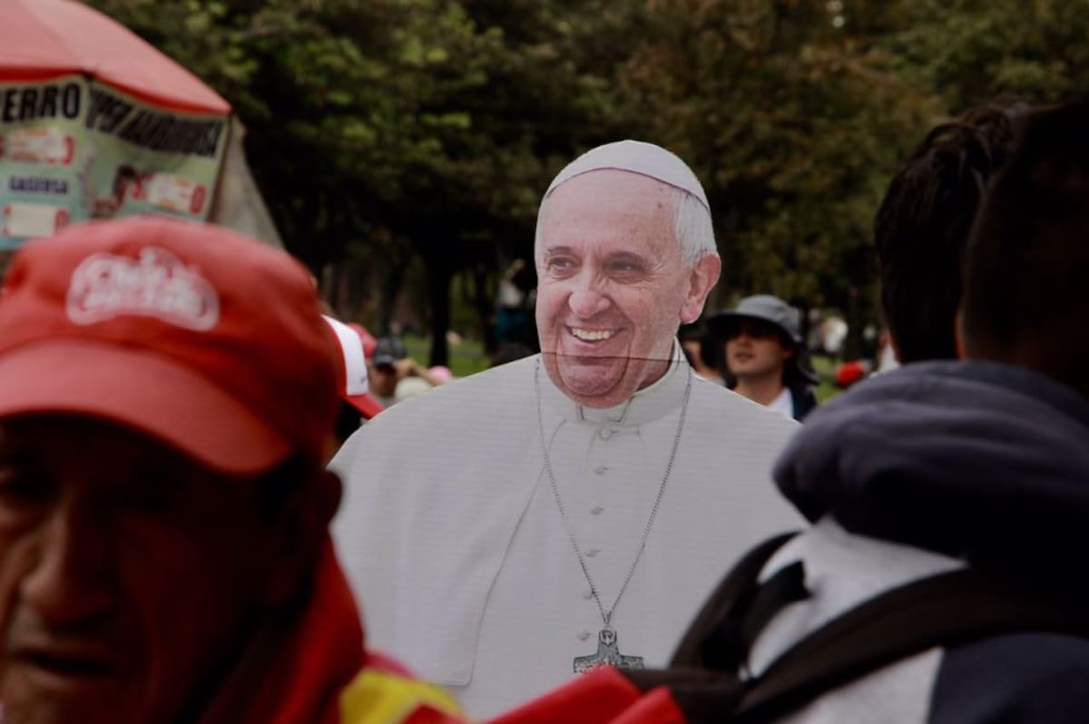 Feligreses caminan con una pancarta del papa Francisco hacia el Parque Simón Bolívar.