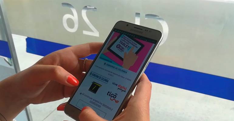 Fotografía de una usuaria conectándose al servicio gratuito de WiFi en una estación de Transmilenio.